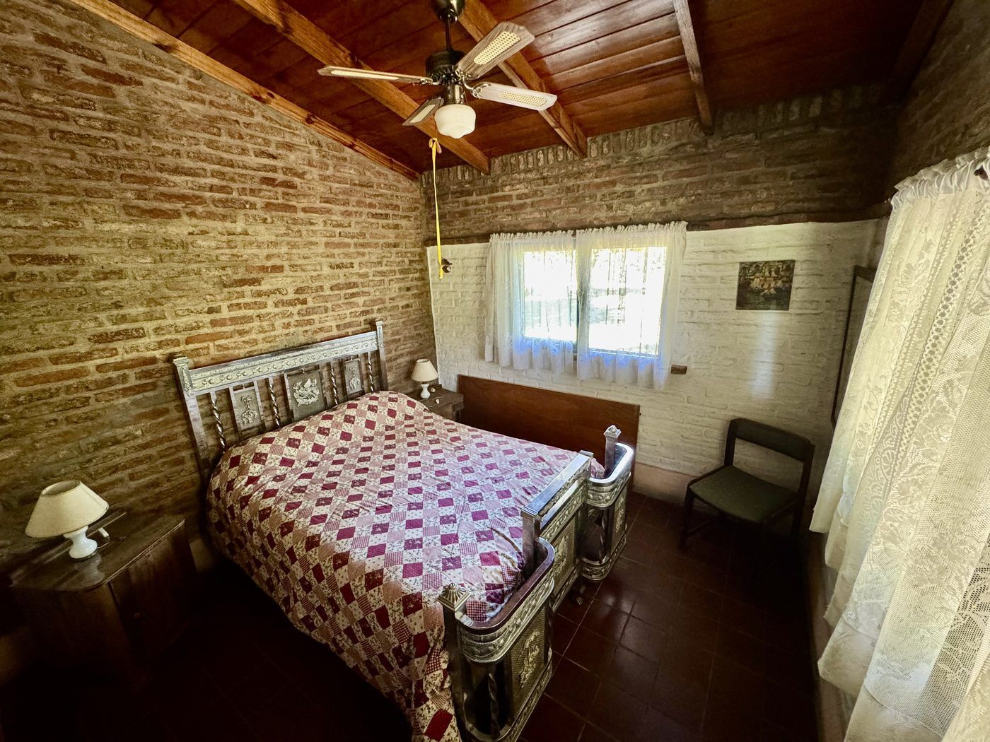 Dormitorio con cama, ventilador de techo y ventana al parque